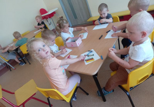 dzieci przy stoliku kolorują